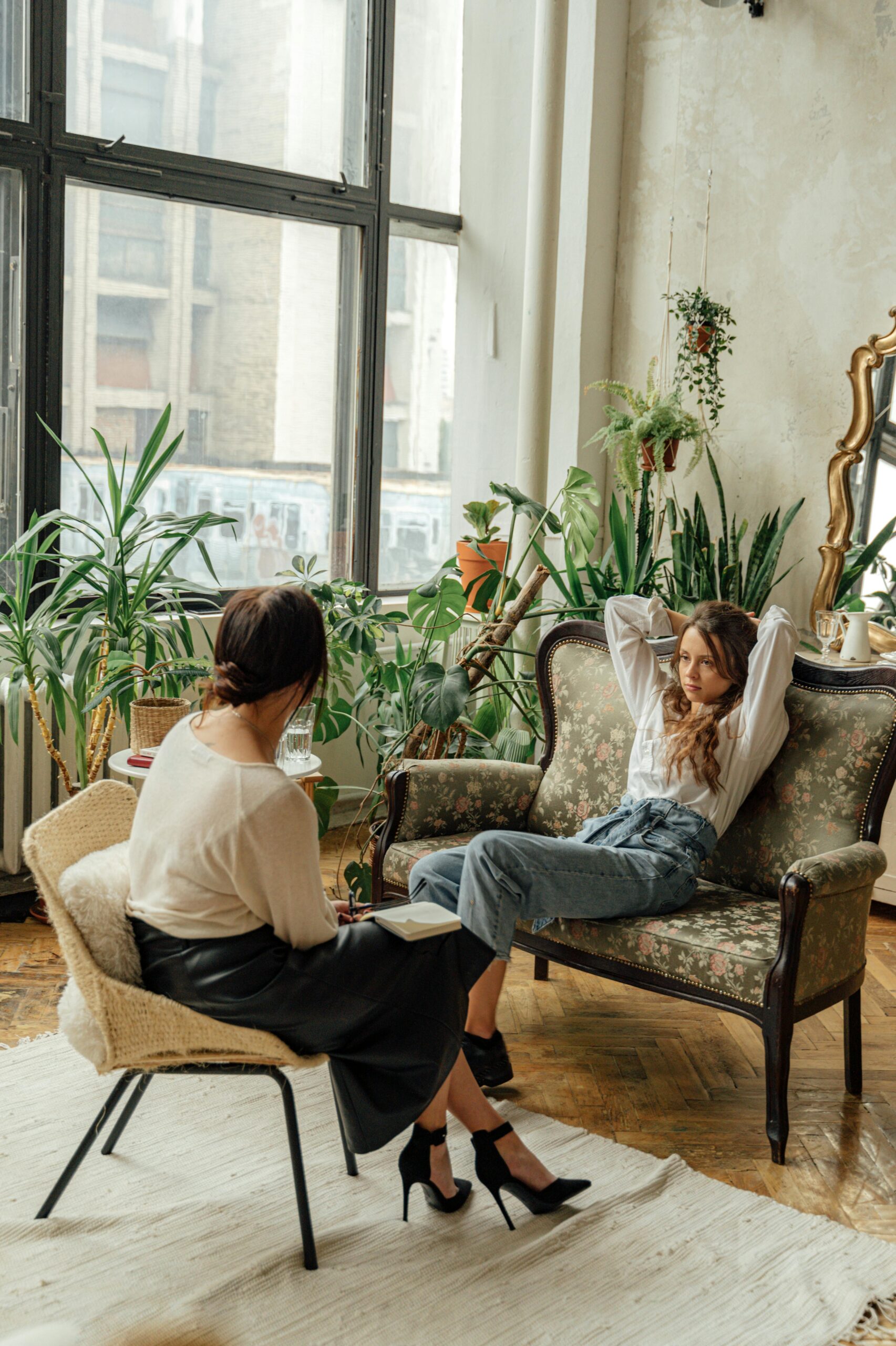 Two women sitting across from one another in a therapy setting.