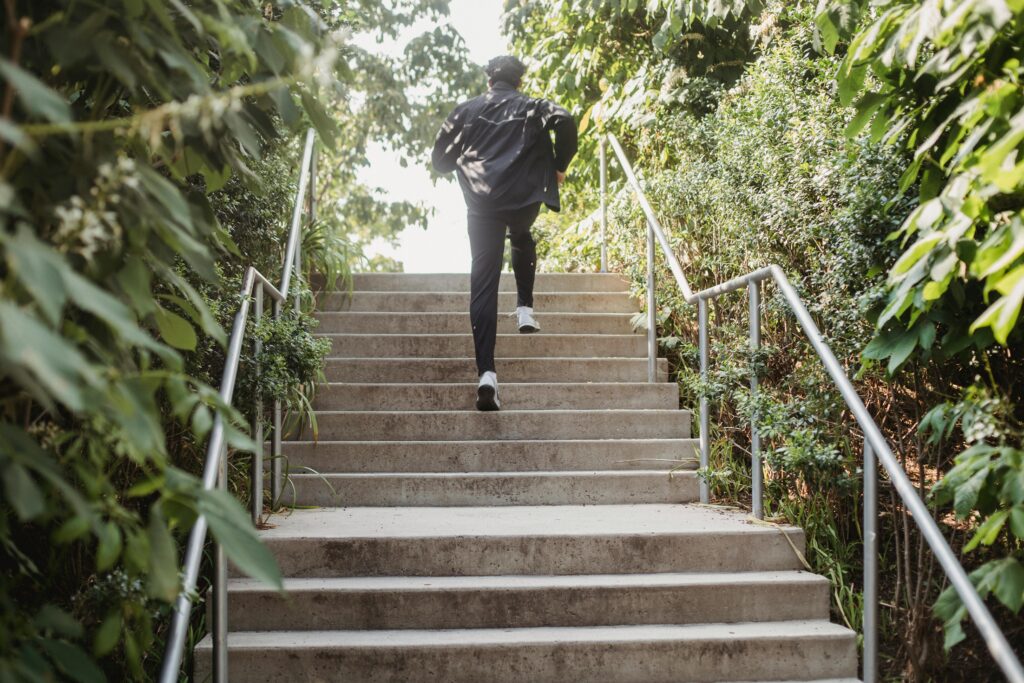 Person running up stairs surrounded by trees.