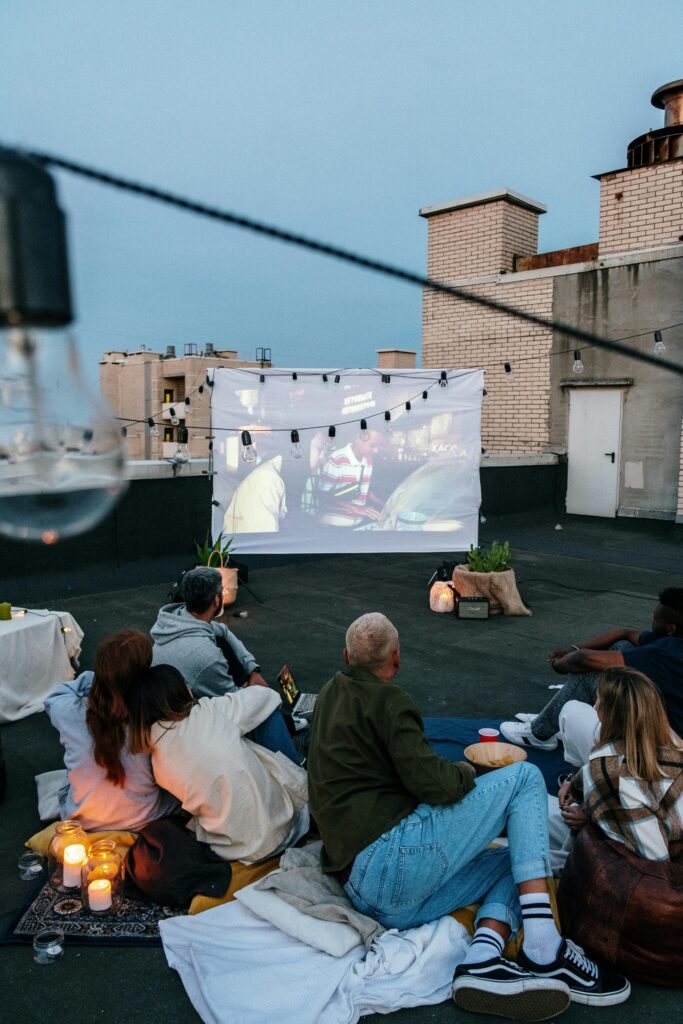 A group of people watching a movie on the rooftop.
